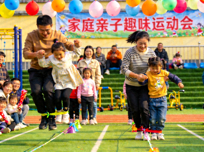 家庭亲子趣味运动比赛现场 - 家长与孩子共同参与体育游戏