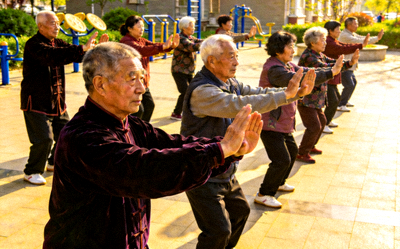 阳光社区老年健身班集体活动 - 老年人在教练带领下练习太极拳