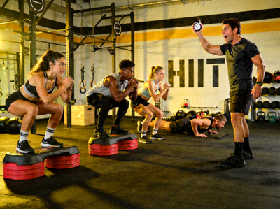 高强度间歇训练（HIIT）课程现场 - 健身者在教练指导下进行训练
