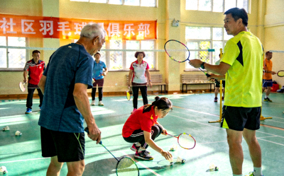 社区居民自发组织的羽毛球俱乐部活动 - 不同年龄段的居民在一起打球