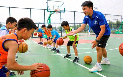 青少年在公益体育课堂上学习篮球基础动作