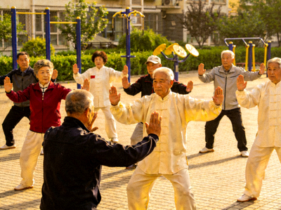 社区老人在教练带领下练习太极拳，动作整齐划一